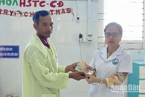 Đại diện Bệnh viện Nhi Gia Lai trao tiền hỗ trợ của các nhà hảo tâm cho đại diện gia đình 3 em nhỏ bị ngộ độc do ăn thịt cóc.