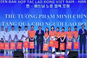 Thủ tướng Phạm Minh Chính tặng quà cho người lao động tiêu biểu Việt Nam tại Hàn Quốc.