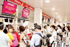 Người dân làm thủ tục tại Sân bay Tân Sơn Nhất. (Ảnh THẾ ANH)