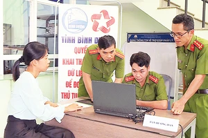 Lực lượng công an cơ sở hướng dẫn người dân khai thác dữ liệu đất đai để thực hiện thủ tục hành chính trong lĩnh vực cư trú.