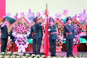  Đại tướng Phan Văn Giang gắn Huân chương Bảo vệ Tổ quốc hạng Nhất lên Quân kỳ Quyết thắng của Quân đoàn 2. Ảnh: Báo Quân đội nhân dân