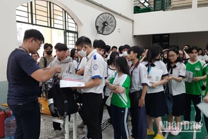 Các thí sinh làm thủ tục gửi đồ tại khu vực gửi đồ ở điểm thi Trường trung học phổ thông Lê Quý Đôn.