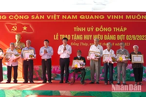 Bí thư Tỉnh ủy Đồng Tháp Lê Quốc Phong trao Huy hiệu Đảng cho các đảng viên. (Ảnh: HỮU NGHĨA)