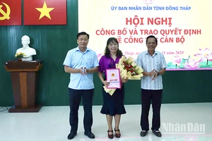 Phó Chủ tịch Ủy ban nhân dân tỉnh Đồng Tháp Nguyễn Phước Thiện (bìa trái) trao quyết định, Giám đốc Sở Nội vụ Phan Hữu Phước tặng hoa chúc mừng nhà báo Ngô Thị Ngọc Hạnh.