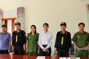 Bị can Nguyễn Thị Hồng Nhung nhận quyết định khởi tố và lệnh bắt tạm giam. (Ảnh: Đinh Thùy/TTXVN)