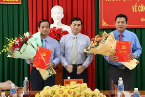 Phó Bí thư Thường trực Tỉnh ủy Bình Thuận Nguyễn Hoài Anh (giữa) tặng hoa chúc mừng đồng chí Võ Thanh Bình (bên trái hình) và đồng chí Tiêu Hồng Phúc. 
