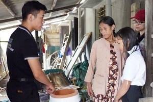 Nhân viên USAID (trái) hỗ trợ người khuyết tật bị ảnh hưởng bởi lũ lụt ở Việt Nam. (Ảnh: USAID)
