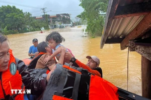 Lực lượng cứu hộ sơ tán em nhỏ khỏi vùng ngập lụt tại thị trấn Catarman, Philippines, ngày 21/11/2023. (Ảnh: AFP/TTXVN)