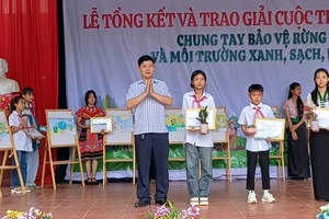 Ông Nguyễn Đức Quang, Trưởng Phòng Giáo dục và Đào tạo huyện Mường Ảng, trao giải cho học sinh Trường Trung học cơ sở Xuân Lao có tranh vẽ xuất sắc về chủ đề môi trường.