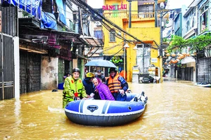 Lực lượng chức năng ứng cứu, giúp người dân khu vực phường Phúc Tân (quận Hoàn Kiếm, Hà Nội) di chuyển đến nơi an toàn khi nước lũ lên nhanh, nhiều khu vực bị ngập sâu. Ảnh: Thành Đạt