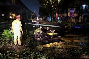 Cảnh sát giao thông tham gia khắc phục hậu quả sau trận mưa lớn đêm 20, rạng sáng 21/4 tại Hà Nội.