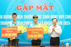 Chủ tịch Ủy ban nhân dân tỉnh Bắc Giang Lê Ánh Dương trao thưởng cho hai học sinh.