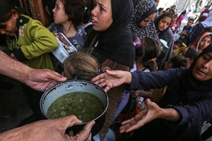 Người tị nạn Palestine nhận thức ăn cứu trợ tại thành phố Deir al-Balah, miền trung Gaza ngày 25/10/2024. (Ảnh: THX/TTXVN)