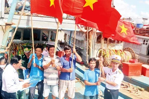 Hải quân Vùng 2 trao cờ Tổ quốc tặng ngư dân thị trấn Ðịnh An, huyện Trà Cú.