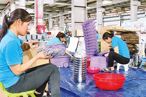 Người lao động tại Công ty TNHH sản xuất nhựa Việt Nhật (huyện Thanh Oai) bắt tay ngay vào công việc từ những ngày đầu xuân. (Ảnh DUY LINH)