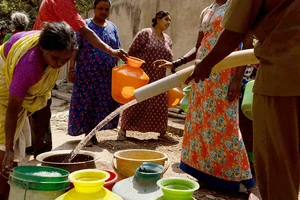 Người dân thành phố Bengaluru, miền nam Ấn Ðộ xếp hàng lấy nước. (Ảnh REUTERS)