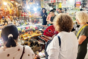 Du khách tham quan gian hàng của tiểu thương tại chợ Bến Thành. (Ảnh CTV)