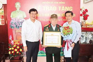 Ðảng viên Hồ Văn Ba (đứng giữa) nhận Huy hiệu 70 năm tuổi đảng. 