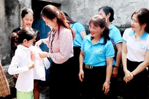 Lãnh đạo Hội Liên hiệp Phụ nữ tỉnh Thanh Hóa và các "Mẹ đỡ đầu" tặng quà cho trẻ mồ côi. (Ảnh THÚY YÊN)
