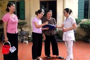 Cán bộ y tế hướng dẫn người dân trên địa bàn Hà Nội phòng chống các bệnh truyền nhiễm.