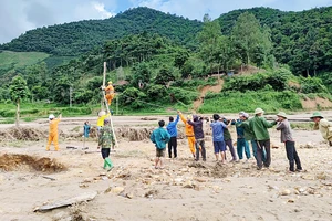 Công nhân Công ty Ðiện lực Sơn La kéo điện lên các bản bị ảnh hưởng mưa lũ của xã Chiềng Nơi, huyện Mai Sơn. (Ảnh LUYỆN NGỌC TUẤN)