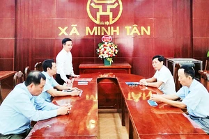 Bí thư Ðảng ủy xã Minh Tân (huyện Phú Xuyên) Trương Ðại Dương (người đứng) chủ trì họp giao ban để nắm bắt thông tin từ cơ sở. (Ảnh HỮU HẢI)