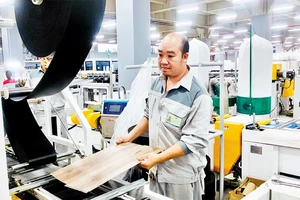 Sản xuất sản phẩm sàn đá công nghệ SPC tại Công ty Pha Lê Plastics (Khu công nghiệp MP Ðình Vũ, Hải Phòng).