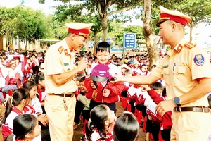 Công an tỉnh Đắk Lắk tuyên truyền, hướng dẫn học sinh đội mũ bảo hiểm đúng quy cách khi tham gia giao thông.