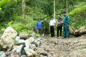 Cán bộ Ủy ban nhân dân thị trấn Lăng Can và người dân kiểm tra hiện trạng các rãnh lũ do mưa lớn gây ra.