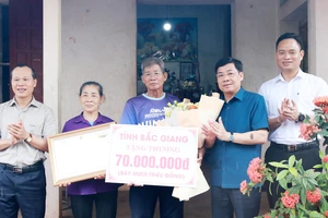 Bí thư Tỉnh ủy Bắc Giang Dương Văn Thái (thứ 2, phải sang) tặng quà cho đại diện gia đình vận động viên Nguyễn Thị Oanh.