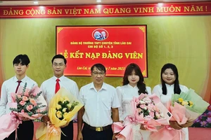 Phó Trưởng Ban Tổ chức Tỉnh ủy Lào Cai Ngô Hữu Quý tặng hoa chúc mừng các đảng viên mới được kết nạp. (Ảnh: TL)