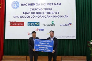 Tổng Giám đốc Bảo hiểm xã hội Việt Nam Nguyễn Thế Mạnh trao tặng tượng trưng hơn 18 nghìn thẻ bảo hiểm y tế và 50 sổ bảo hiểm xã hội cho đại diện Ủy ban nhân dân tỉnh Sơn La. (Ảnh: VSS)