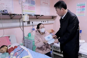 Tổng Giám đốc Bảo hiểm xã hội Việt Nam Nguyễn Thế Mạnh tặng quà cho bệnh nhi có hoàn cảnh khó khăn tại Bệnh viện Nhi Trung ương. Ảnh: TRUNG TÂM