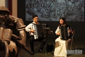 Hai nghệ sĩ accordion Nguyễn Quỳnh Chi và Vũ Việt Hưng biểu diễn trong không gian trưng bày các tác phẩm mỹ thuật về Chiến dịch Điện Biên Phủ tại Bảo tàng Mỹ thuật Việt Nam. (Ảnh: THANH BÌNH) 