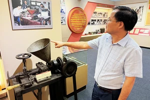 Phó Cục trưởng Chính trị-Tổ chức Khúc Hữu Mạnh giới thiệu máy đúc chữ nhựa - một sáng kiến nổi bật của ngành cơ yếu những năm 70. (Ảnh NGỌC ĐINH)