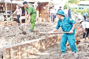 Lực lượng vũ trang cùng các đoàn thể chính trị xã Huyền Hội, huyện Càng Long, tỉnh Trà Vinh, hỗ trợ người dân xây nhà. (Ảnh: KHỞI - GIANG)