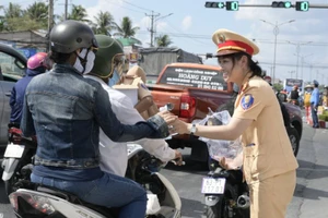 Cảnh sát giao thông tỉnh Bình Thuận tặng nước cho người dân dưới tiết trời nắng nóng.