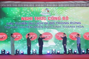 Các đại biểu thực hiện nghi thức khai trương tuyến du lịch đi bộ trong rừng.