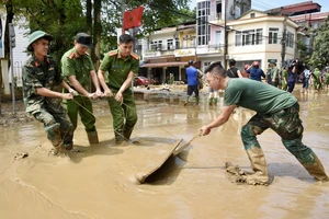 Các lực lượng quân đội và công an giúp nhân dân dọn dẹp vệ sinh môi trường sau bão lũ tại thành phố Yên Bái (Ảnh: Trần Hải). 