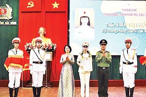 Thiếu tá Bùi Thị Phượng (đứng giữa) nhận Giải thưởng “Phụ nữ Công an Đắk Nông tiêu biểu lần thứ 2” do Giám đốc Công an tỉnh trao tặng.