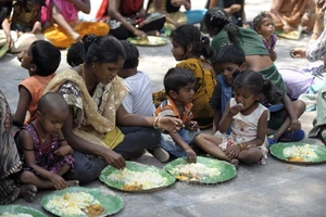 Ảnh minh họa: Người vô gia cư nhận thức ăn từ một chương trình cứu trợ dành cho người nghèo ở Hyderabad, Ấn Độ. Ảnh: AFP/TTXVN
