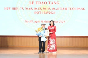 Phó Bí thư Thường trực Thành ủy Hà Nội Nguyễn Thị Tuyến trao huy hiệu 75 năm tuổi Đảng tặng đồng chí Trần Quang An. (Ảnh: Quang Thái)