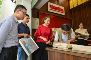 Họa sĩ Nguyễn Văn Mạc - trưởng nhóm tác giả bức panorama “Chiến dịch Điện Biên Phủ” ký tặng độc giả Báo Nhân Dân.