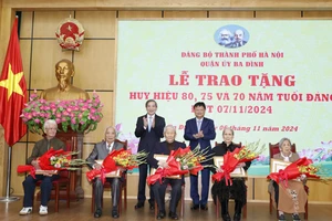 Trưởng Ban Tổ chức Thành ủy Hà Nội Vũ Đức Bảo và Bí thư Quận ủy Ba Đình Hoàng Minh Dũng Tiến trao Huy hiệu Đảng tặng các đảng viên lão thành.