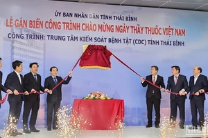 Các đại biểu thực hiện nghi thức gắn biển công trình chào mừng Ngày Thầy thuốc Việt Nam cho tòa nhà CDC Thái Bình.