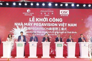 Các đại biểu thực hiện nghi thức bấm nút khởi công nhà máy sản xuất kính áp tròng tại khu công nghiệp Liên Hà Thái (tỉnh Thái Bình).