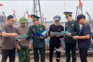 Lực lượng Bộ đội Biên phòng tỉnh Thái Bình phát tờ rơi tuyên truyền về chống khai thác IUU cho ngư dân.