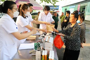 Y, bác sĩ trong đoàn công tác Bộ Y tế trao thuốc cho người dân nghèo tỉnh Điện Biên.