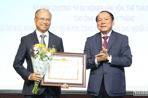 Bộ trưởng Nguyễn Văn Hùng trao tặng Kỷ niệm chương cho Đại sứ Đinh Toàn Thắng. (Ảnh: KHẢI HOÀN)