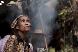 Người Chứt rất thích hút thuốc, cả phụ nữ và trẻ em đều hút. Nhà nào cũng trồng cây thuốc lá trên nương. (Ảnh: Vụ Văn hóa dân tộc)